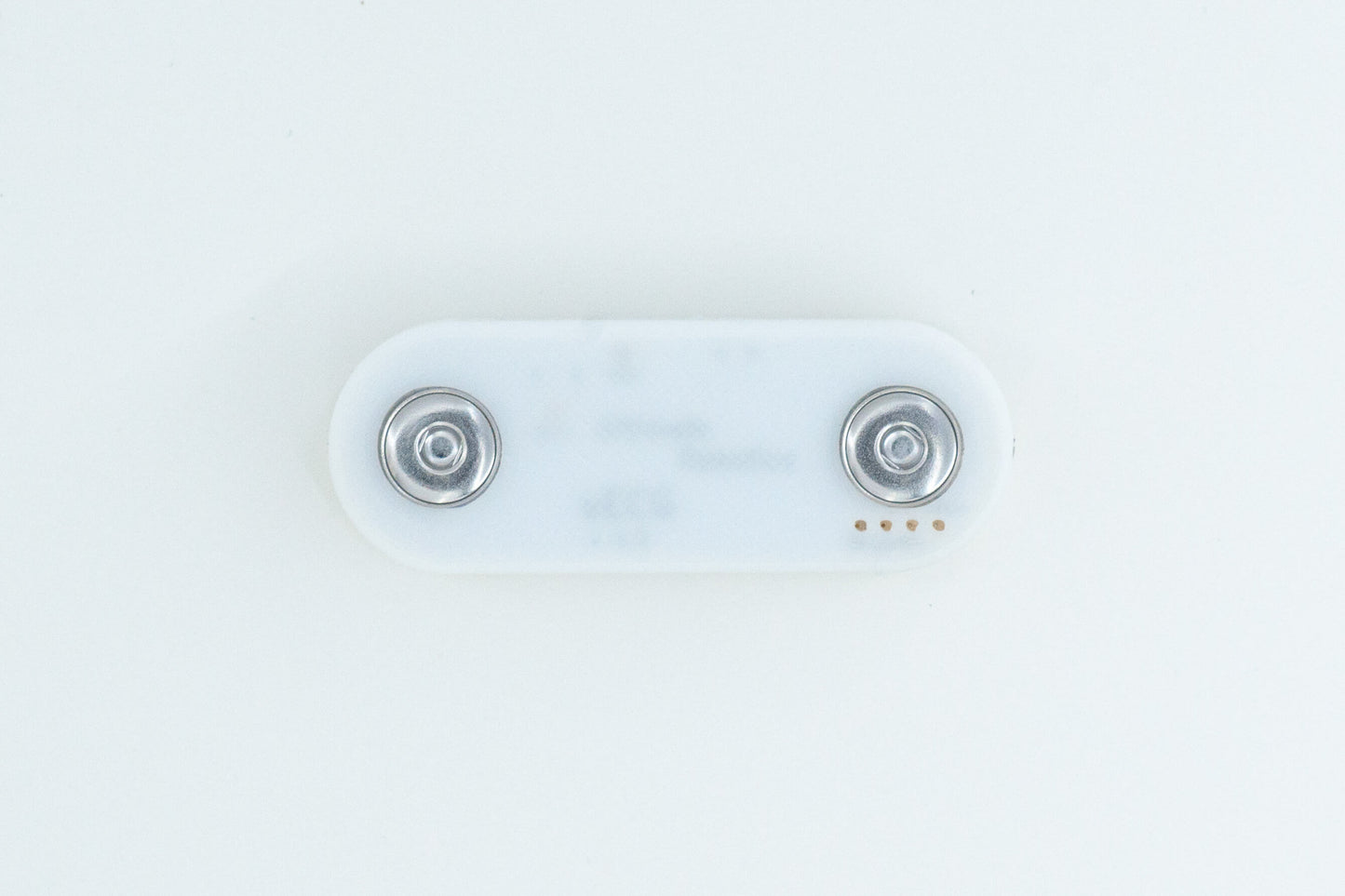 uECG ECG sensor, on white background, in a white 3D printed case, with visible electrode snap connectors (view from the bottom)
