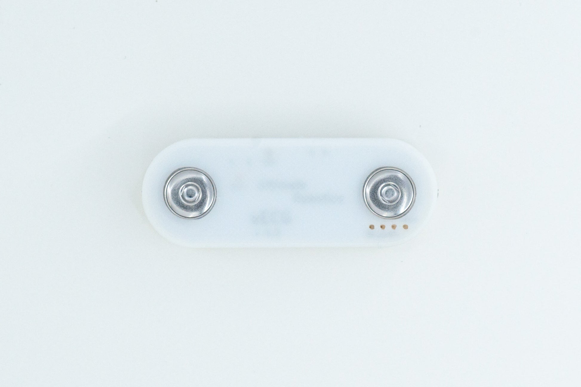 uECG ECG sensor, on white background, in a white 3D printed case, with visible electrode snap connectors (view from the bottom)